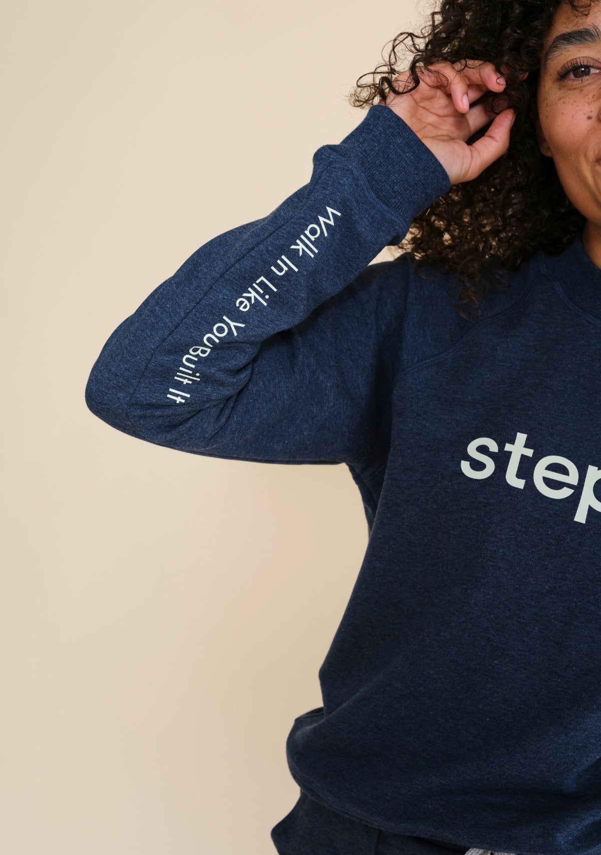 Close-up of Walk In Like You Built It slogan printed on right sleeve of Step Up raglan sweatshirt