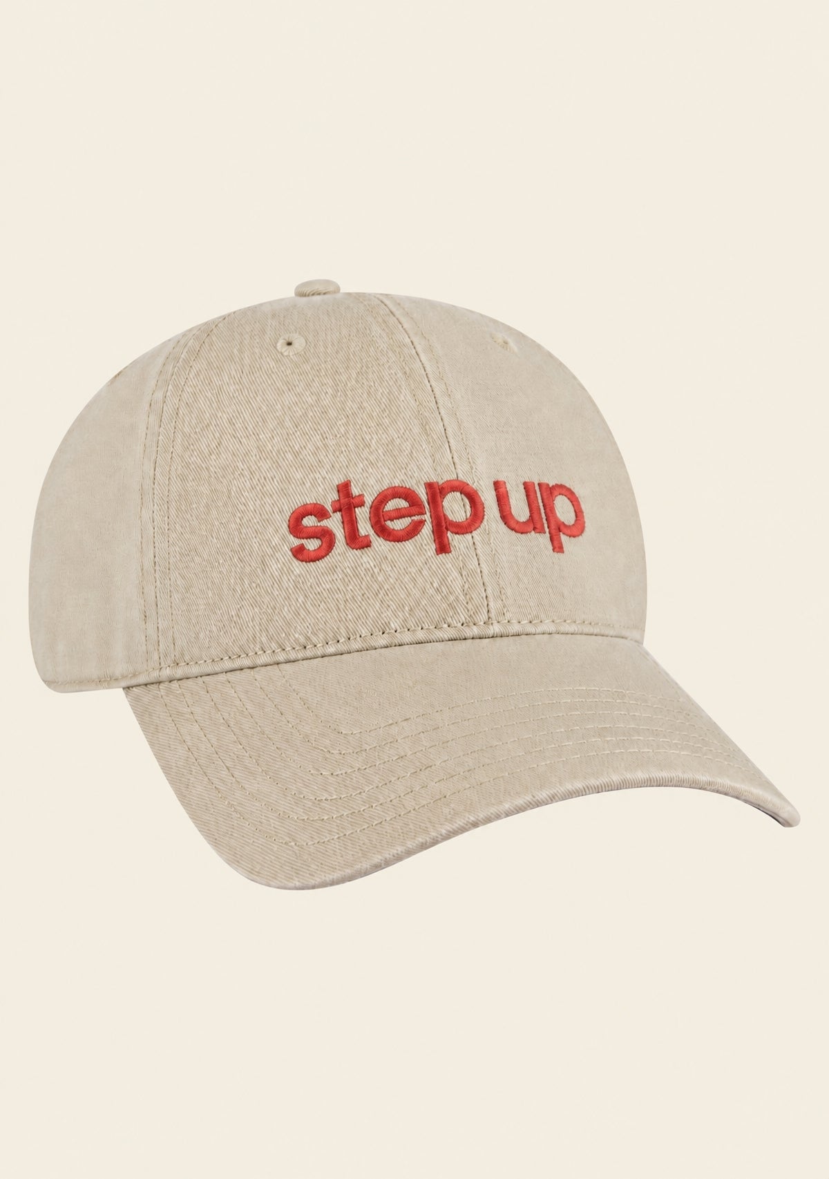 Close-up of Step Up logo embroidery on beige baseball cap
