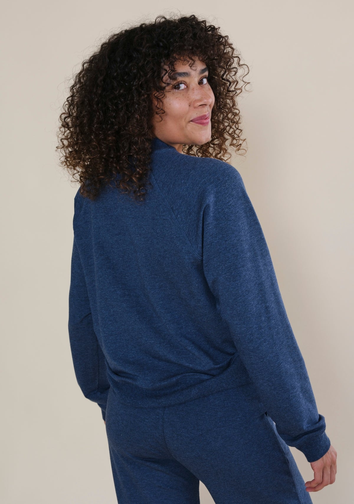 Back view of women's Step Up raglan crewneck sweatshirt with relaxed fit and ribbed hem