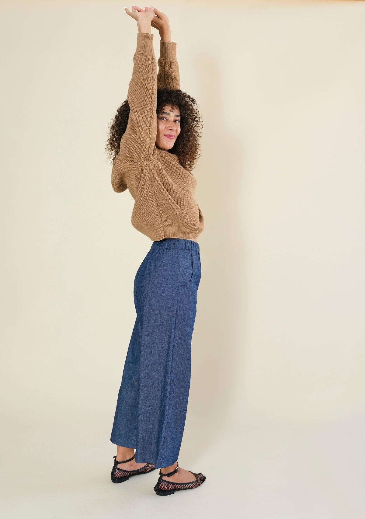 Side profile of women's blue denim wide leg pants with relaxed silhouette and cropped hem