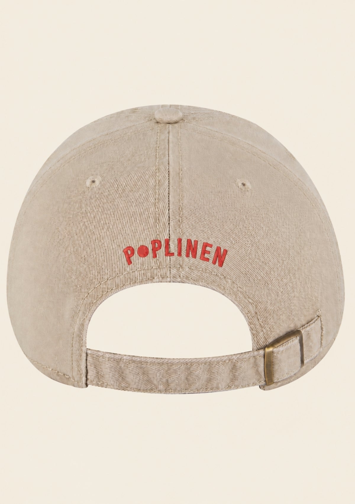 Adjustable snap-button closure on cream baseball cap with opening for ponytail